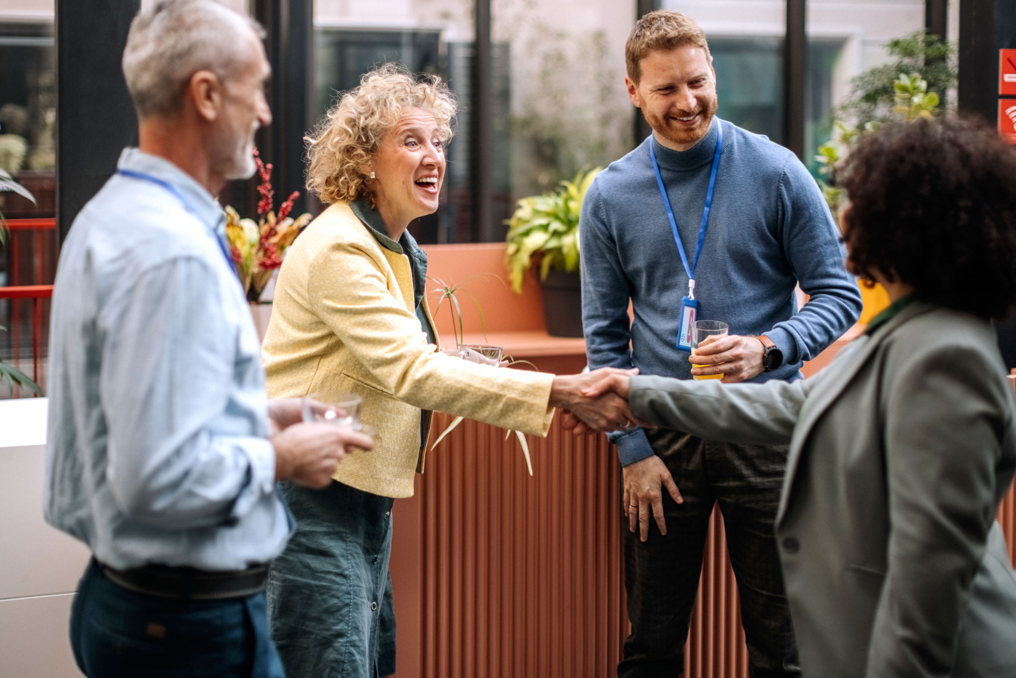 People networking and shaking hands at event.