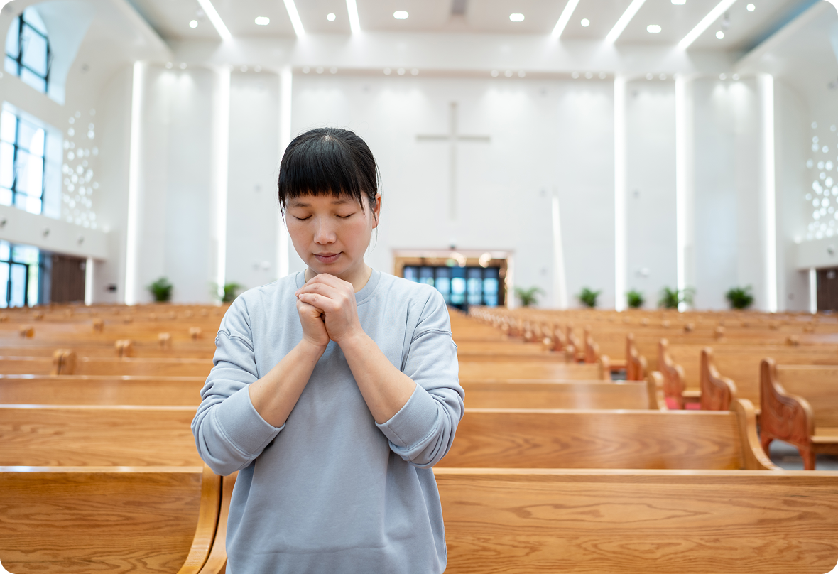 Person praying inside a large church.