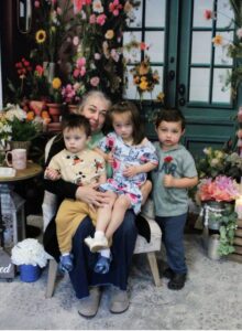 Grandmother with three children among flowers.
